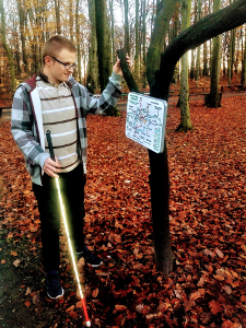 Fotografia: Uczestnik wycieczki przed tablicą informującą o szlakach spacerowych